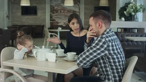 Couple fighting in front of child at cafe or restaurant. Daughter closing her 스톡 동영상 72733717