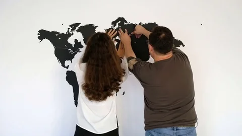 Couple is fixing the world map | Stock Video | Pond5