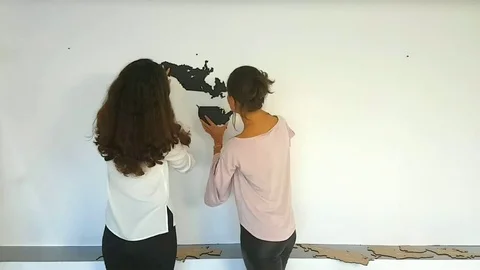 Couple is fixing the world map | Stock Video | Pond5
