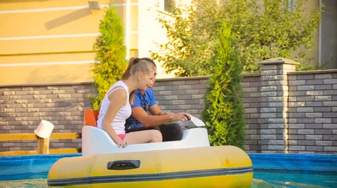 Couple floating around inside electric rubber boat Stock Footage 63577979