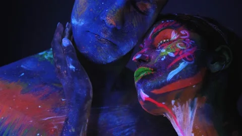 Couple with fluorescent makeup posing at camera, colorful pattern on their skin. Stock Footage 132526178