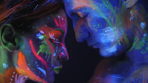 Couple with fluorescent makeup posing at camera, unusual colorful pattern. Stock Footage 221341989