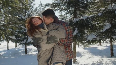 Couple fooling around during date in the snowy park. A young red-haired woman Stock Footage 236773317