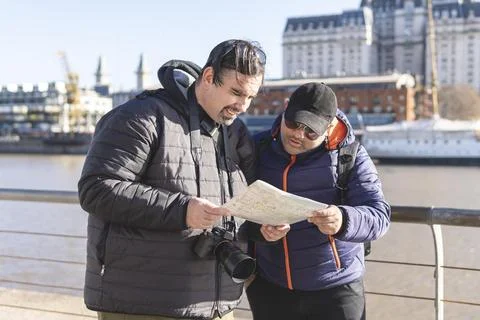 Couple of friends consulting the map while exploring Puerto Madero Buenos Aires Fotos Stock