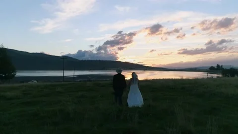 A couple in front of a lake at sunset. Stock Footage 215143833