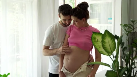 Couple of future parents hugging and husband caresses belly of pregnant wife Stock Footage 244411207