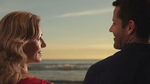 Couple gazing at one another while standing on beach. Stock Footage 43681329