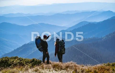 The couple gesturing on the mountain with a beautiful view Stock Photos