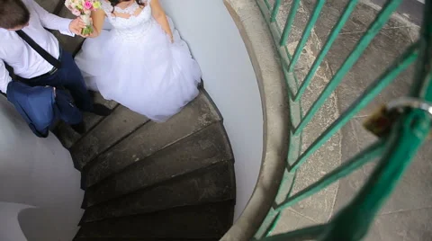 Couple goes down the spiral staircase Stock Footage 63906281