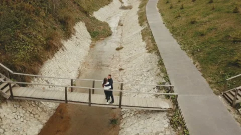 Couple goes over the bridge Stock Footage 127887649