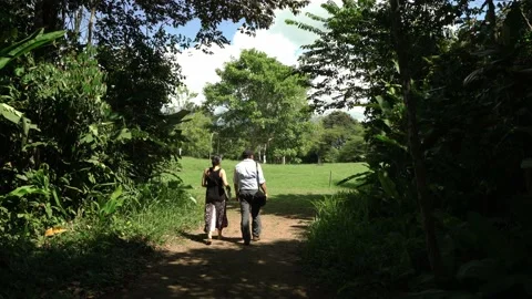 Couple going away down trail to Finca 6 village Video stock 206502054