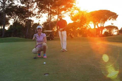 Couple on golf course at sunset Fotos de archivo