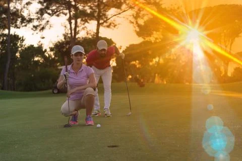 Couple on golf course at sunset Fotos de archivo