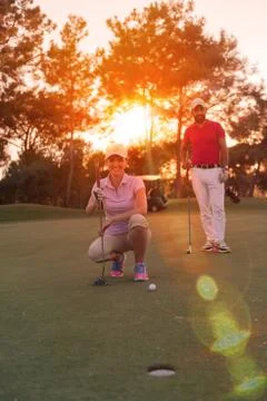 Couple on golf course at sunset Fotos de archivo