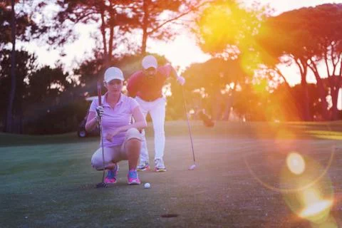 Couple on golf course at sunset Fotos de archivo