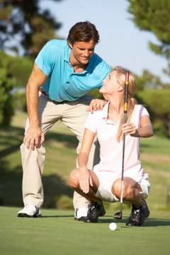 Couple Golfing On Golf Course Lining Up Putt On Green Stock Photos