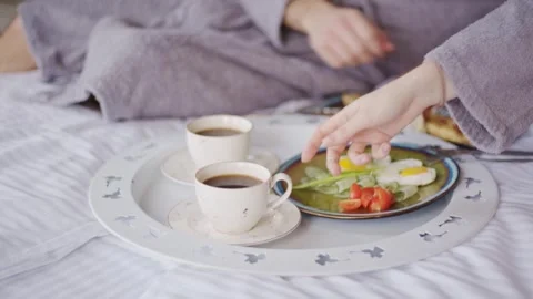 Couple in gray bathrobes Breakfast in bed at the hotel. Room service in a modern Stock Footage 242010963
