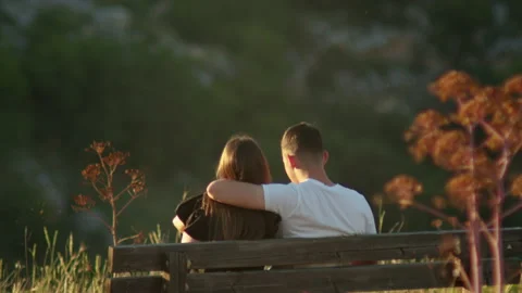 A couple of guys is sitting on a bench talking in an embrace Video stock 141866253