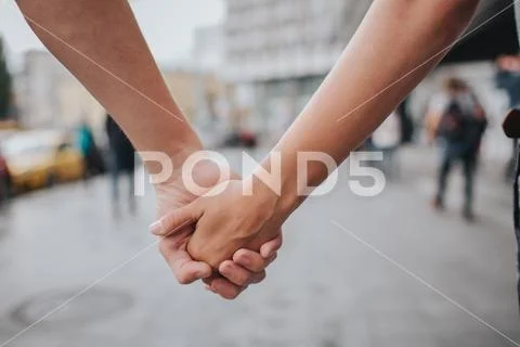 Couple hands closed together outdoors in love and romantic relationship. Close Stock Photos