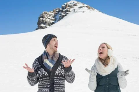 Couple with hands open standing in front of snowed hill Stock Photos