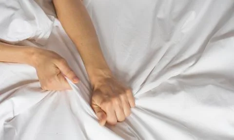 Couple hands pulling white sheets in ecstasy, orgasm. Concept of passion Stock Photos