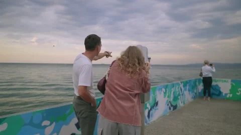 A Couple Happily looking into binocular at the Beach Together, sunset time Stock Footage 291703193