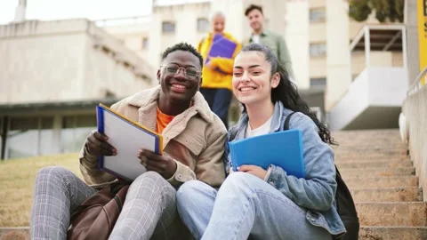 A couple of happy multiethnic students smiling and looking at camera. In the Stock Footage 210111724
