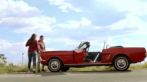 Couple have broken down with mechanical fault while driving a classic cherry red Video stock 199632028