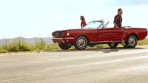 Couple have broken down with mechanical fault while driving a classic cherry red Stock Footage 199632035