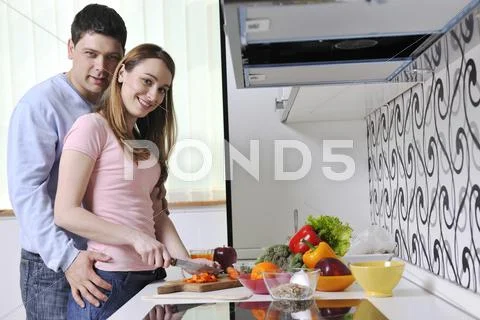 Couple have fun and preparing healthy food in kitchen Stock Photos