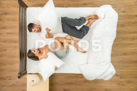 The couple have a fun on the bed. View from above Stock Photos