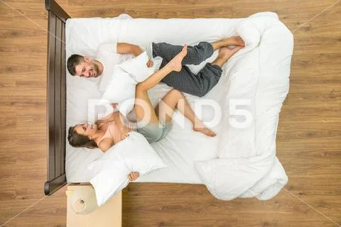 The couple have a fun on the bed. View from above Stock Photos