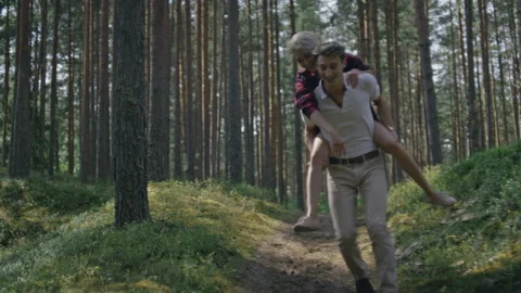 Couple have fun, run in forest on piggy back Stock Footage 162725895