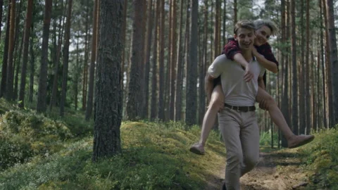 Couple have fun, run in forest on piggy back Stock Footage 163241518