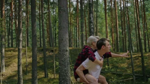 Couple have fun, run in forest on piggy back Stock Footage 163241971