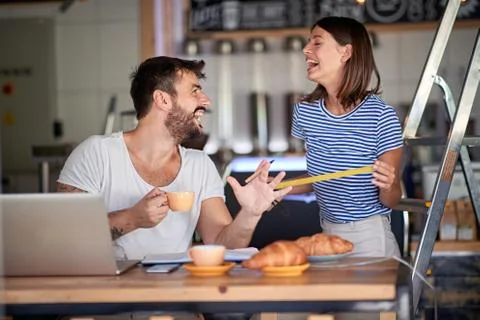 Couple having breakfast and fun in coffee shop that they are about to open. s Stock Photos