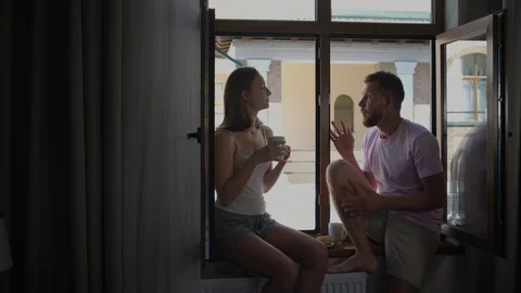 Couple having breakfast and talking by the window Stock Footage 120943628