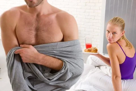 Couple having breakfast in bed Stock Photos