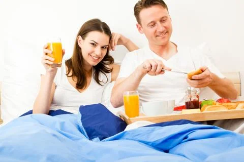 Couple Having Breakfast In Bed Stockfoto's