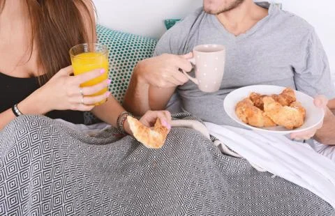 Couple having breakfast in bed. Stock Photos