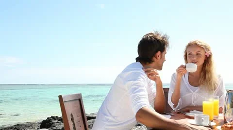 Couple having breakfast by blue lagoon Stock Footage 14827718