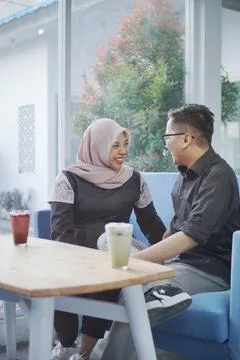 Couple having coffee on a date talking and smile together. shot through win.. Stock Photos