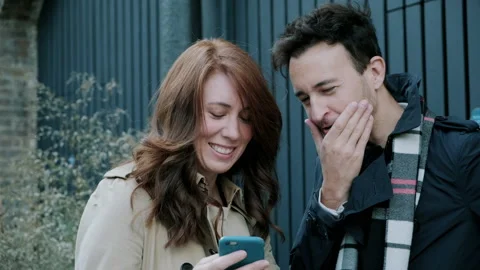 Couple having a conversation while looking at phone Stock Footage 130598903