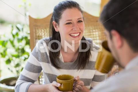 Couple Having Cup Of Coffee On Patio