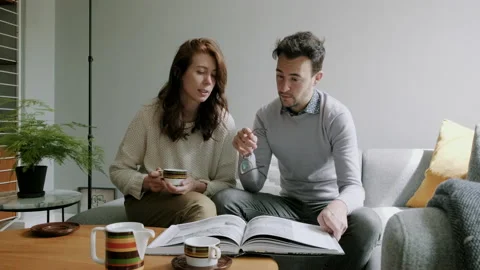 Couple having a discussion while looking down at a book Stock Footage 130640443