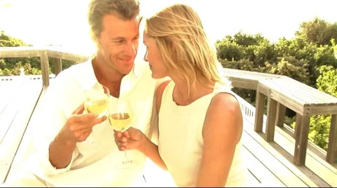 Couple having drinks on veranda Stock Footage 43684796