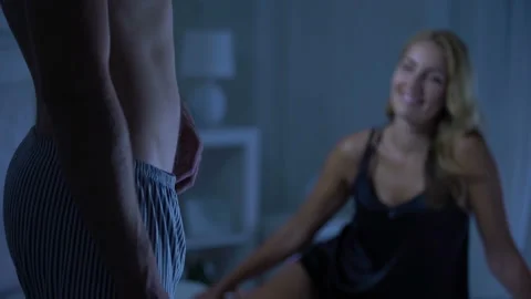 Couple having foreplay man pulling pajamas trousers, romantic relations, potency Vídeos de archivo 98109242