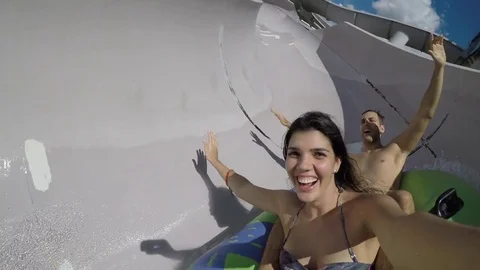 Couple having fun and sliding down in a water slide Stock Footage 72495577