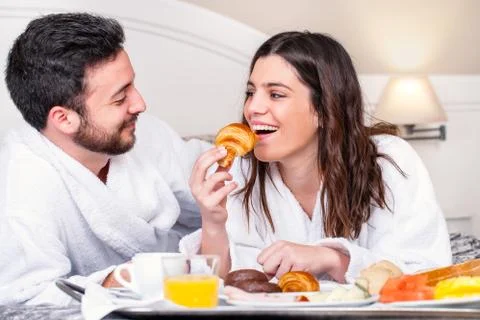Couple having fun at breakfast in hotel room. Stock Photos