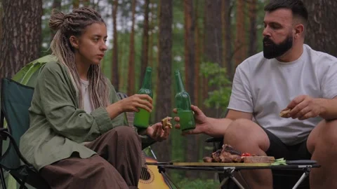 Couple having fun camping and enjoying a picnic dinner in the forest Stock Footage 327530022